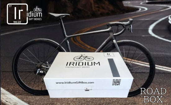 Iridium gift box with a bicycle on a road, featuring the brand logo.